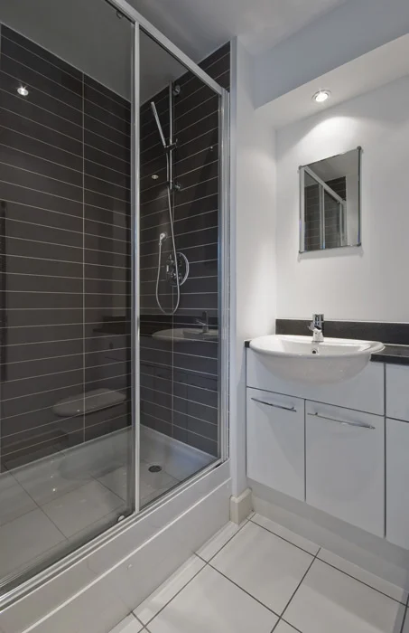 Framed sliding shower screen fitted beside a compact vanity