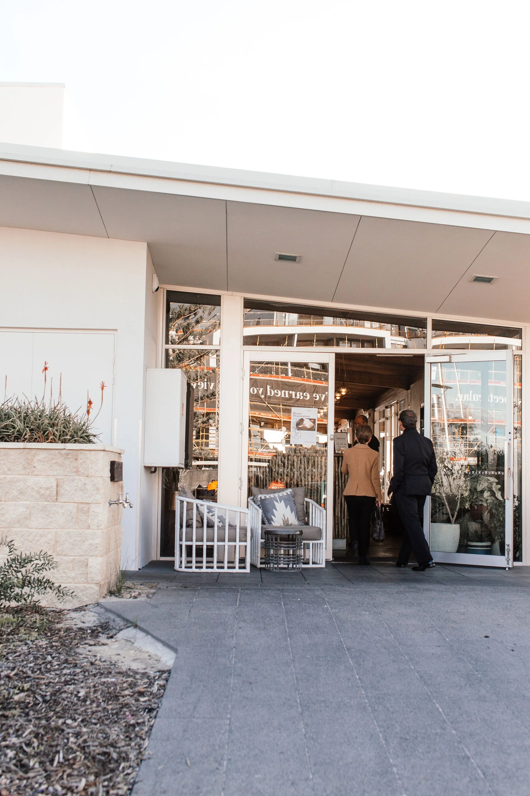 Glass-fronted retail entrance with customers entering