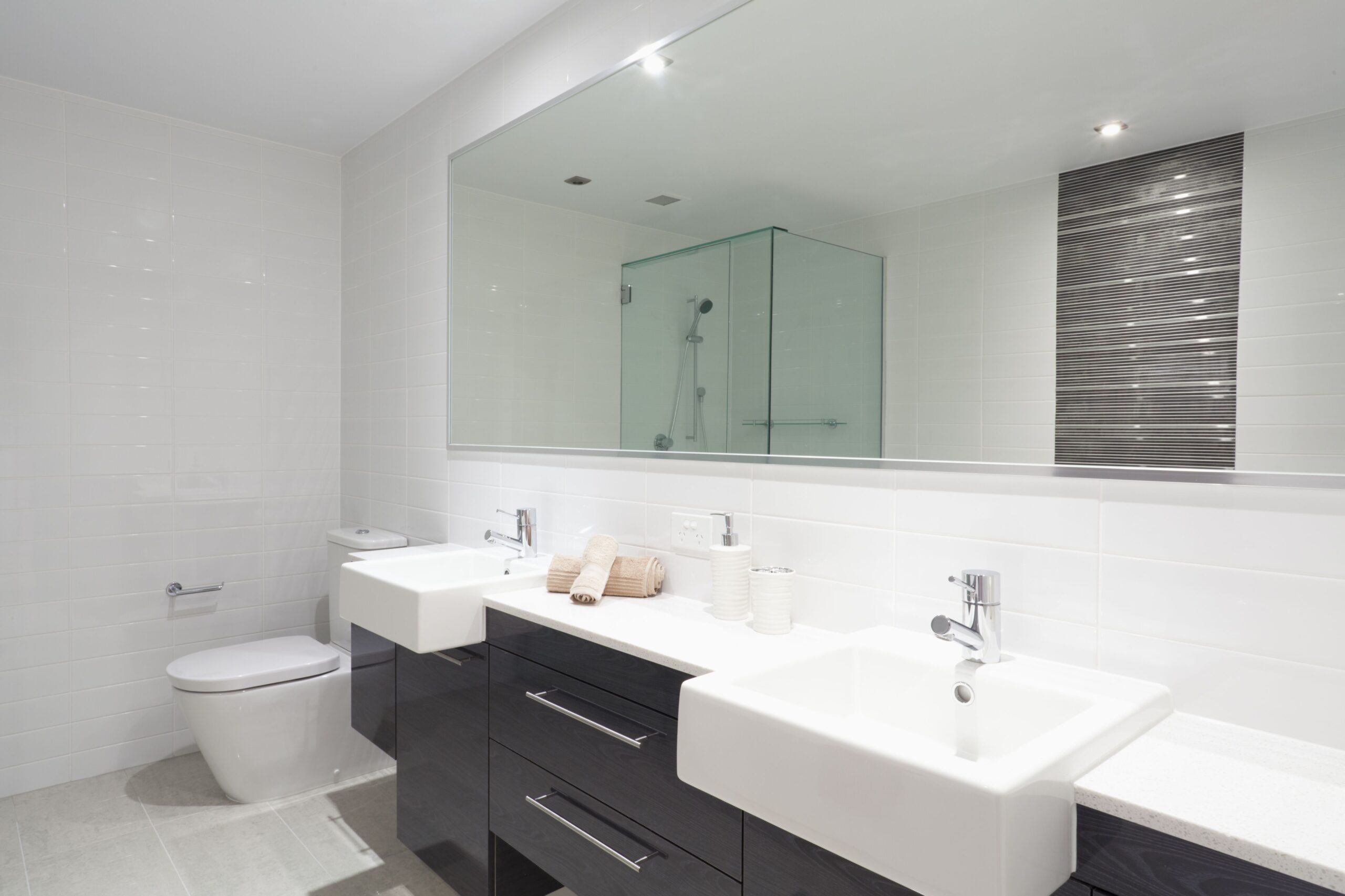 Large custom bathroom mirror installed above a double vanity